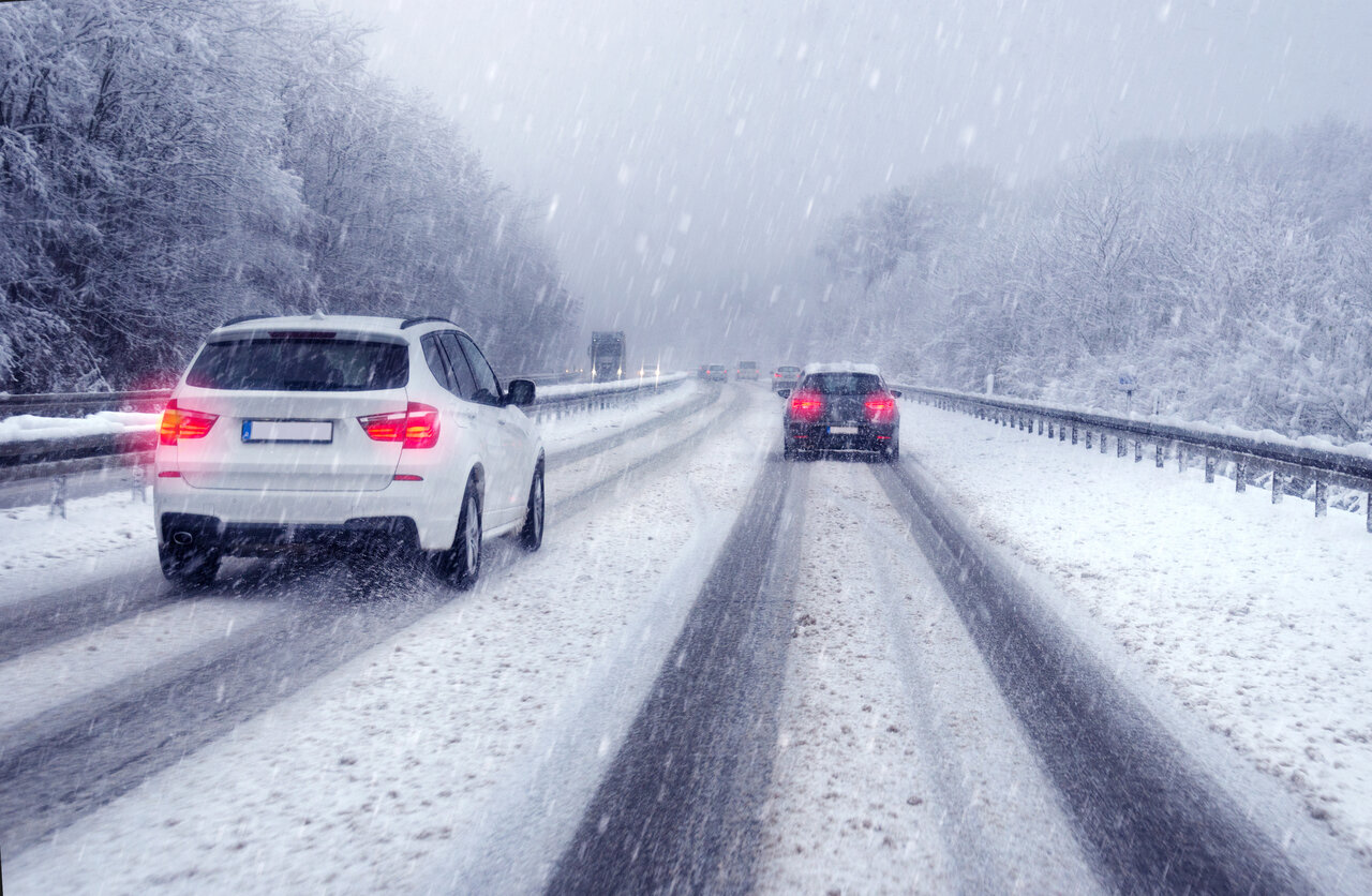 Winter driving tips white car driving on snow highway